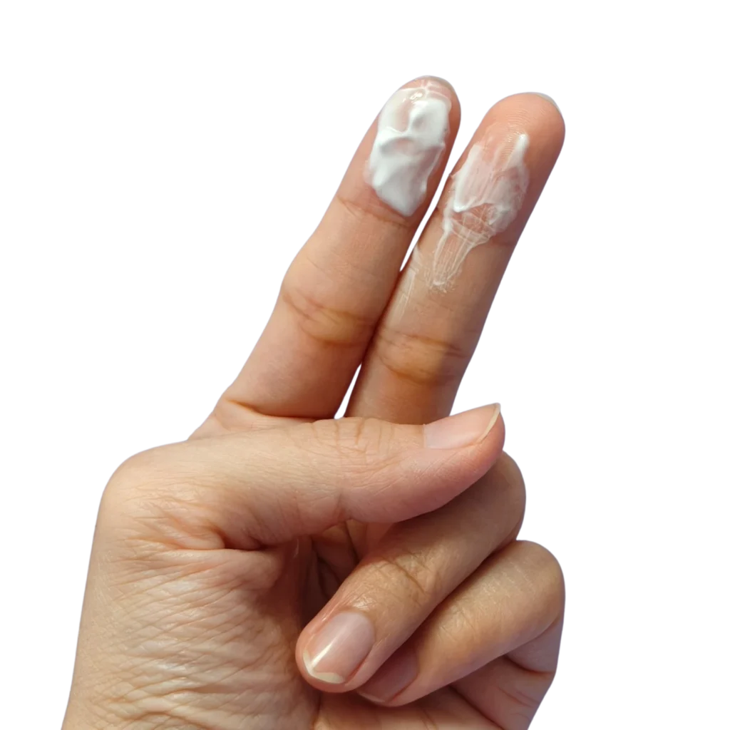 Primer plano de una mano con dos dedos extendidos, en los que se adhiere un moco cervical blanquecino y cremoso.